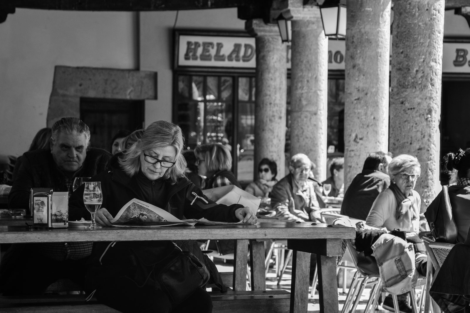 A woman reading the sports pages at an outdoor cafe, Plaza Mayor, Valladolid